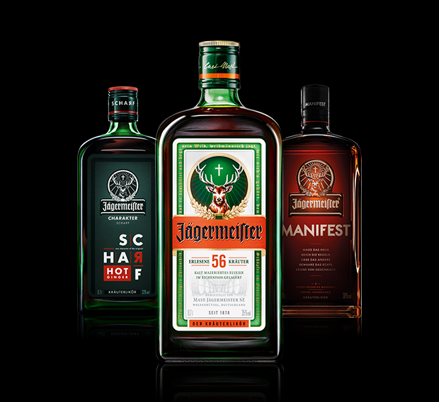 Eine Flasche Jägermeister steht im Vordergrund, eine Flasche Manifest und eine Flasche Jägermeister Scharf stehen im Hintergrund