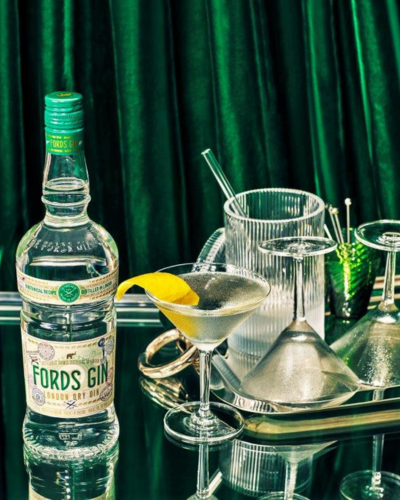 Fords Gin Flasche mit vollen Gläsern und Zitrone